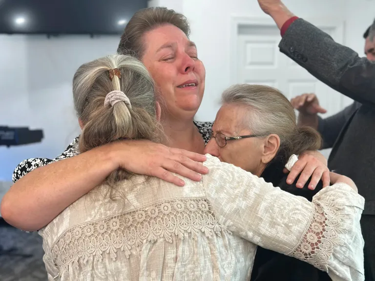 Three ladies praying for one another in an embracing hug